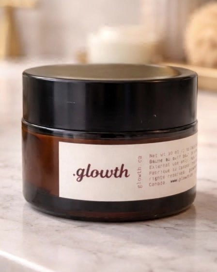 The Glowth face balm in an amber glass jar on a marble counter